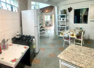 uma cozinha com um frigorífico e uma mesa em Refúgio perto do Mar: Ótima casa a 350m da praia em Pontal do Paraná
