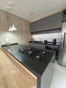 a kitchen with a black counter top and a stove at Apt completo Caruaru, 2 quartos in Caruaru +14 photos