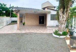 ein Haus mit einer Auffahrt davor in der Unterkunft Refúgio perto do Mar: Ótima casa a 350m da praia in Pontal do Paraná