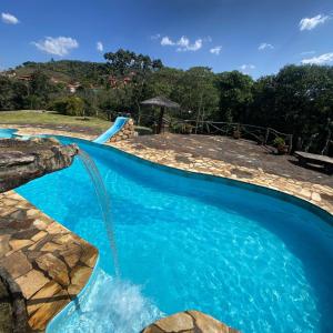 a swimming pool with a water slide in a yard at Pousada Chalés Vale do Sol in Conceição da Ibitipoca
