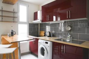 a kitchen with a sink and a washing machine at Pleasant love cocoon of 30 m in Clichy in Clichy