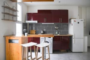 a kitchen with purple cabinets and a white refrigerator at Pleasant love cocoon of 30 m in Clichy in Clichy