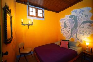a bedroom with a bed and a painting on the wall at Soul - moradia criativa in Vila Franca de Xira