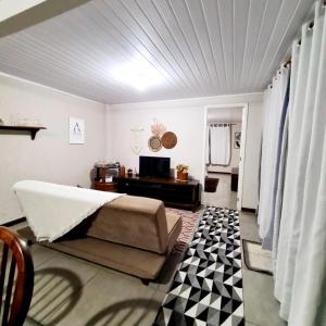 1 dormitorio con 1 cama y TV. en Hospedagem Doce Lar - Casa Manacá, en Teresópolis
