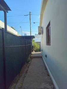 a hallway of a white building with a fence at La Tata in Alta Gracia