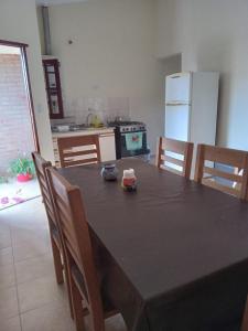a kitchen with a table with chairs and a refrigerator at La Tata in Alta Gracia