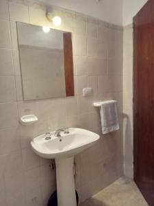 a bathroom with a sink and a mirror at La Tata in Alta Gracia