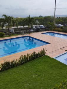 una gran piscina con un patio de ladrillo y césped en apartamento cerca al aeropuerto parqueadero privado conjunto cerrado bilbao, en Cúcuta