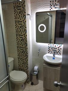 a bathroom with a toilet and a sink and a mirror at apartamento cerca al aeropuerto parqueadero privado conjunto cerrado bilbao in Cúcuta