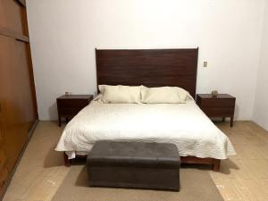 a bedroom with a large bed with a wooden headboard at Meson la Esperanza in Lagos de Moreno