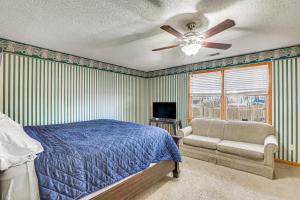 een slaapkamer met een bed, een plafondventilator en een stoel bij Mount Pleasant Home with Yard, Sunroom and Game Room! in Charleston