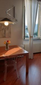 a dining room table with a vase of flowers and a window at Acquamarina in Rapallo