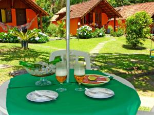 uma mesa com uma toalha de mesa verde e copos de vinho em pousada no caminho do escorrega em Visconde de Mauá