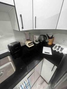 a small kitchen with a black counter top at Cozy & Private Entire Basement in Winnipeg