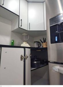 a kitchen with white cabinets and a refrigerator at Cozy & Private Entire Basement in Winnipeg