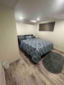 a bedroom with a bed with a comforter on it at Cozy & Private Entire Basement in Winnipeg