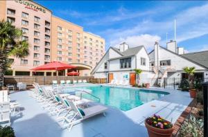 une piscine avec des chaises longues et un hôtel dans l'établissement Heart of Houston NRG/TMC Beautiful Studio 77030, à Houston