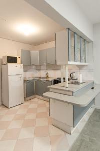 eine Küche mit weißen Schränken und einem weißen Kühlschrank in der Unterkunft Amazing Apartment Near La Costanera in Asunción