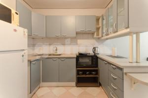 a kitchen with gray cabinets and a white refrigerator at Amazing Apartment Near La Costanera in Asuncion