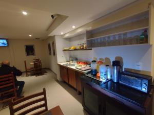 a kitchen with a counter and a person sitting in a room at Hotel Plaza Olido in Sao Paulo
