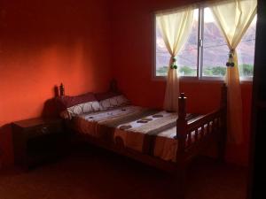 ein Schlafzimmer mit einem Bett und zwei Fenstern in der Unterkunft Maima Host II in Maimará