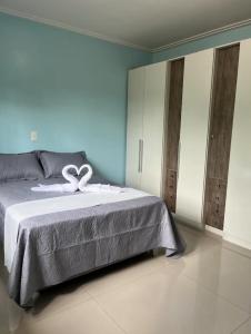 a bedroom with a bed with a ribbon on it at Casa Recanto dos Pássaros in Três Coroas