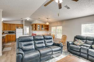 a living room with two leather couches and a kitchen at 4 Mi to State Park Peaceful Rockport Home with Yard in Rockport