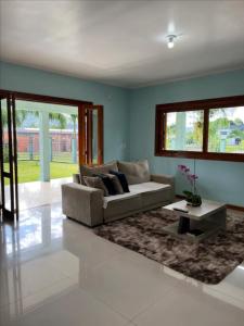 a living room with a couch and a coffee table at Casa Recanto dos Pássaros in Três Coroas