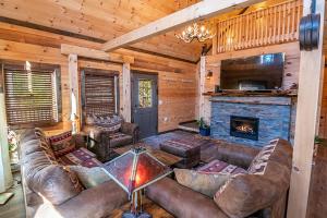 una sala de estar con sofás y una chimenea en una cabaña en Downhill Lodge, en Lake Placid