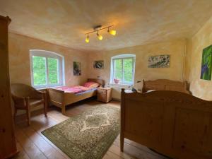 Schlafzimmer mit einem Bett, einem Stuhl und Fenstern in der Unterkunft Erholen und Wohlfühlen Auf dem Knick in Detmold