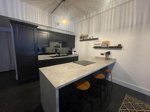 a kitchen with a counter with stools and a sink at Castaway Liverpool Weekly Stays in Liverpool
