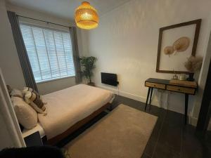 a bedroom with a bed and a window and a table at Castaway Liverpool Weekly Stays in Liverpool