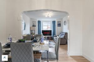 a dining room and living room with a table and chairs at Modern House, Sleeps 5 in Central Coventry in Coventry