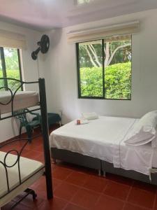 a bedroom with two bunk beds and a window at Casa finca La alegría - casa el Recreo in La Mesa