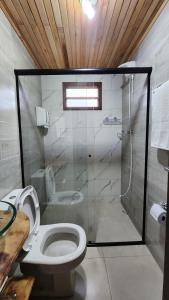 een badkamer met een toilet en een glazen douche bij Chalés Monte Verde in Bom Jardim da Serra