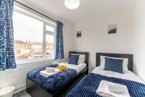 1 dormitorio con 2 camas y ventana en Modern House, Sleeps 5 in Central Coventry en Coventry