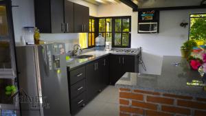 una cucina con un frigorifero e un lavandino di Chalet Lupe-Eje cafetero a Palestina