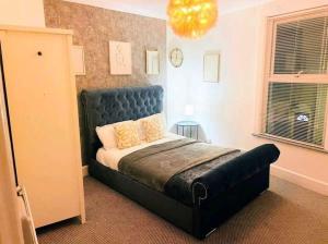una camera con letto con testata blu di King Charles House a Gillingham