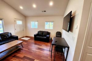 a living room with black leather furniture and a flat screen tv at Blocks To The Beach Huge Private Fence Yard Home in Oceanside