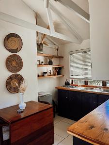 a kitchen with a counter and plates on the wall at Stanley Island in Plettenberg Bay