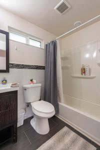 a white bathroom with a toilet and a shower at Blocks To The Beach Huge Private Fence Yard Home in Oceanside