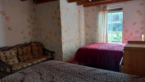 um quarto com 2 camas, um sofá e uma janela em Casona San Jorge em Lucre