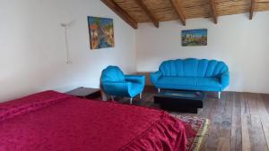 um quarto com uma cama e duas cadeiras azuis em Casona San Jorge em Lucre