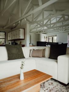 a living room with a white couch and a table at Stanley Island in Plettenberg Bay