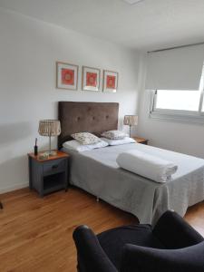 1 dormitorio con 1 cama grande y 1 silla en Moderno apartamento con vista en Montevideo
