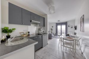 a kitchen with a sink and a table in it at Central 3 - 10 min Paris - 30 min Disney - Free Parking - 5 min RER A in Fontenay-sous-Bois