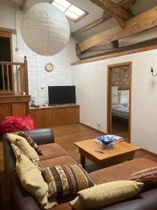 ein Wohnzimmer mit einem Sofa und einem Tisch in der Unterkunft La maison de Léon in Celles-sur-Belle