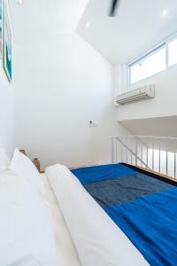 坎古的住宿－The Blue Loft Canggu - free scooter use，白色的卧室设有床和窗户