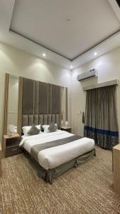 ein Schlafzimmer mit einem großen Bett in einem Zimmer in der Unterkunft شهرزاد للأجنحة الفندقية in Abū Qa‘ar