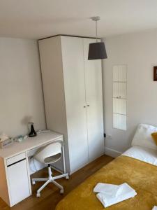 1 dormitorio con escritorio, 1 cama, escritorio y silla en Private Rooms in Euston, Central London (135), en Londres